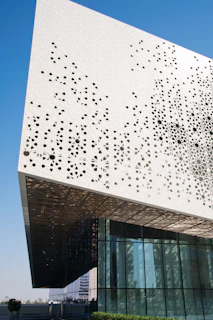 Modern commercial building showcasing perforated aluminum cladding with precise geometric patterns.