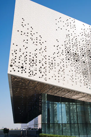 Modern commercial building showcasing perforated aluminum cladding with precise geometric patterns.