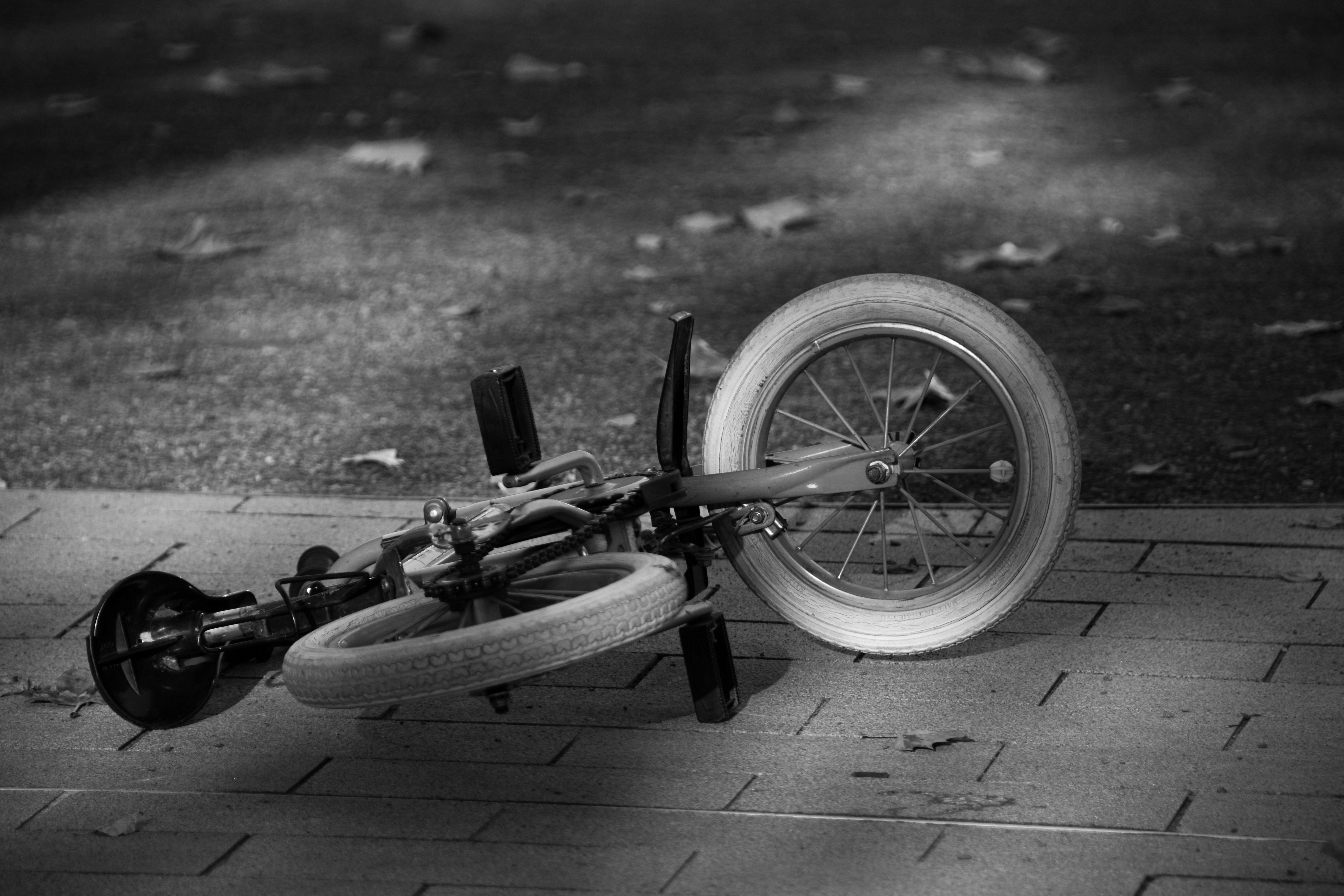 a black and white photo of a broken bicycle