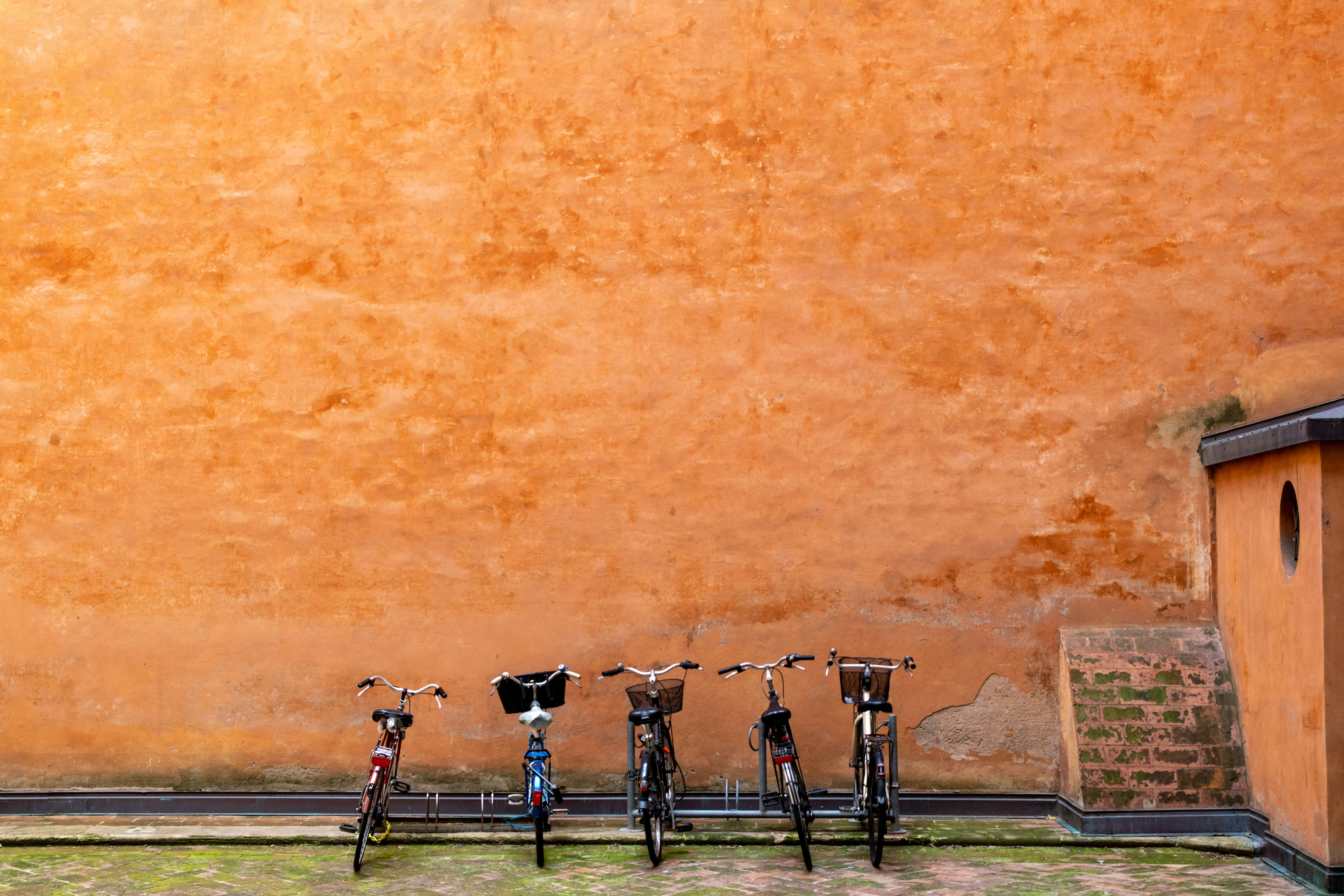 a row of bikes parked next to a wall
