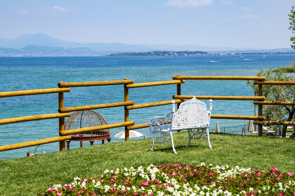 a white bench sitting on top of a lush green hillside