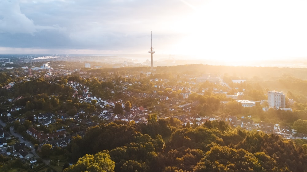 an aerial view of a city with a tower in the background