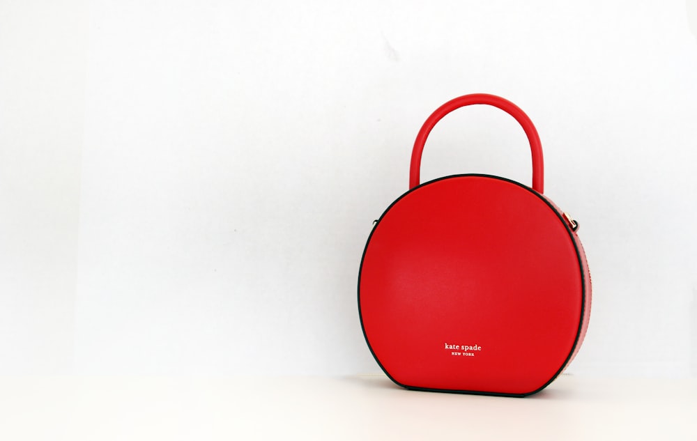 a red purse sitting on top of a white table