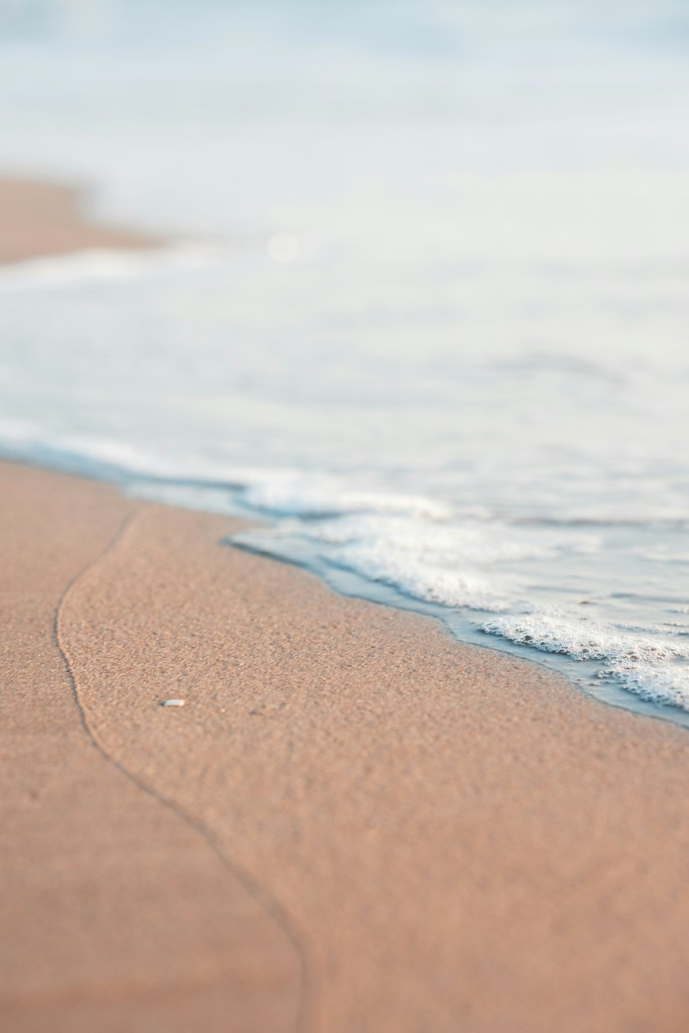 a blurry photo of a beach with waves coming in