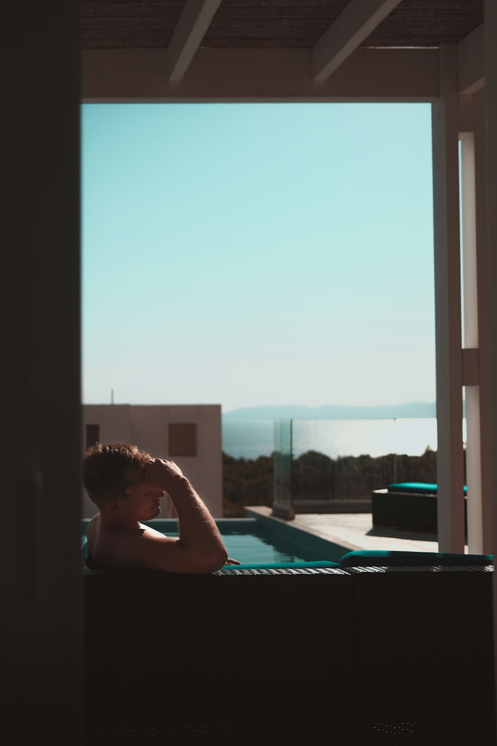 a man sitting in a hot tub with a view of the ocean