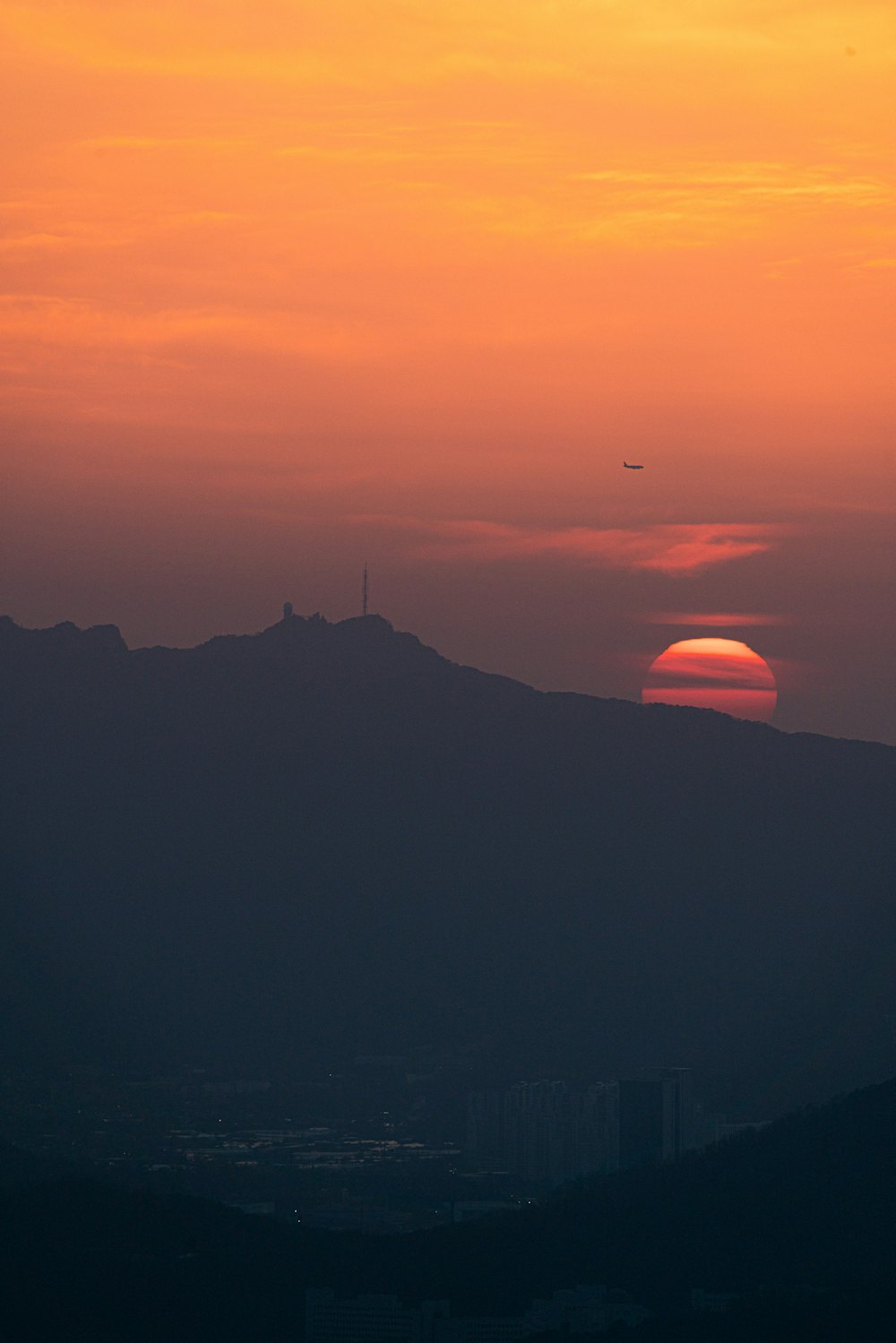 the sun is setting over a mountain range