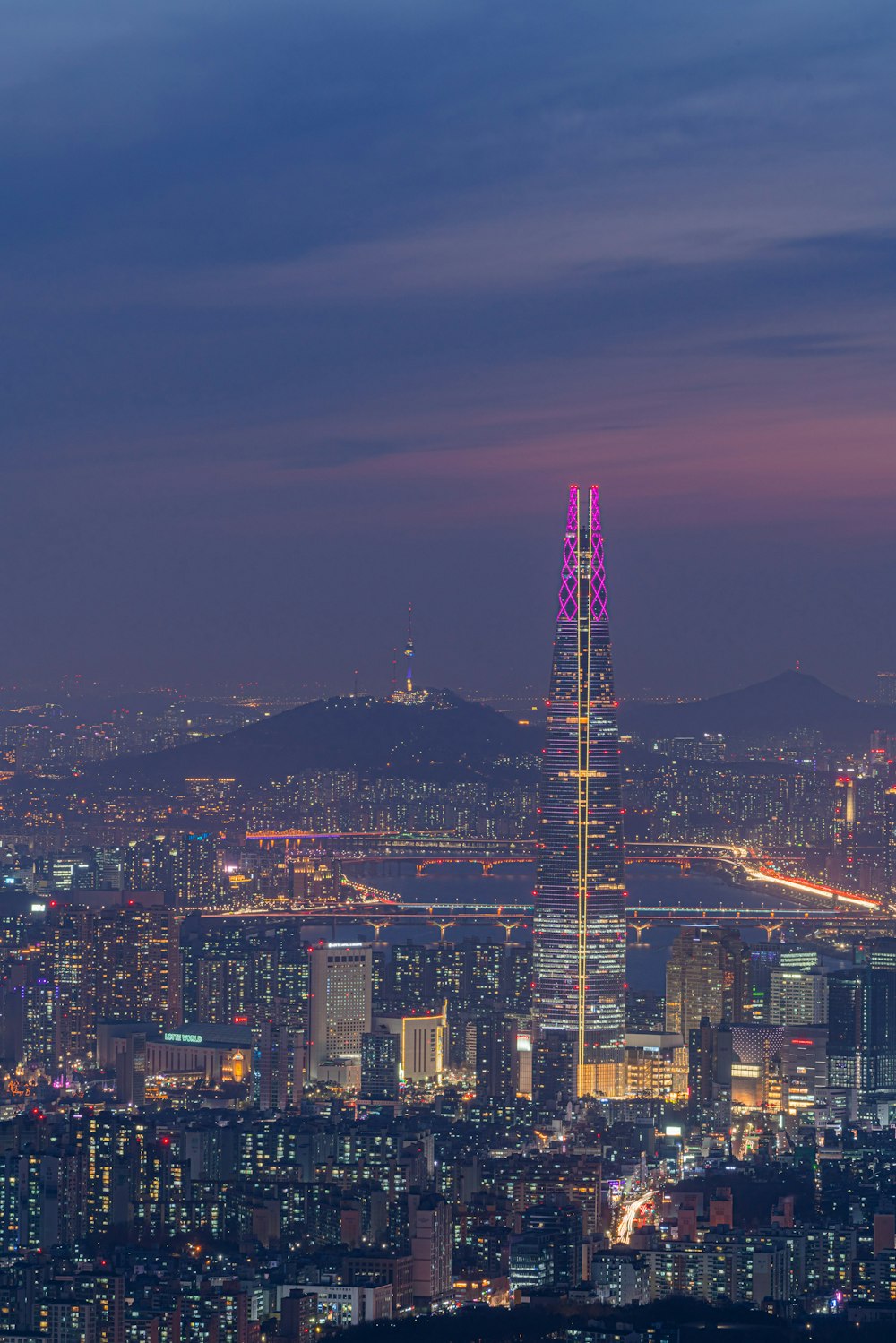 a view of a city at night from the top of a hill