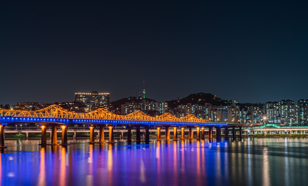 a bridge over a body of water with a city in the background