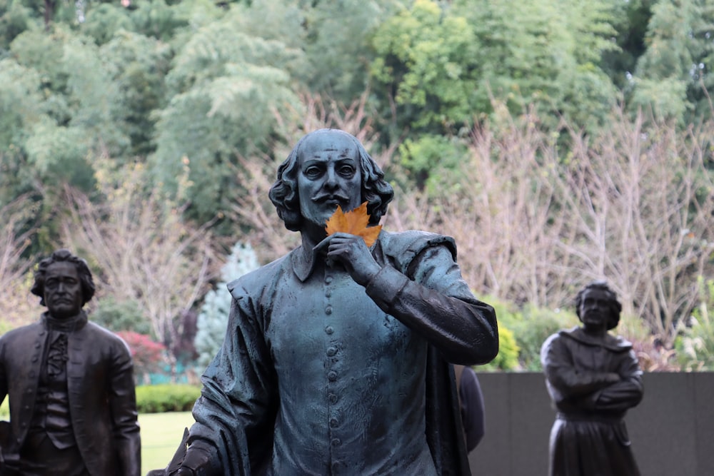 Una estatua de un hombre sosteniendo una flor naranja