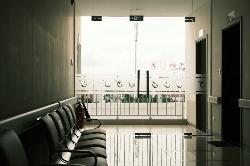 a row of black chairs sitting in a hallway