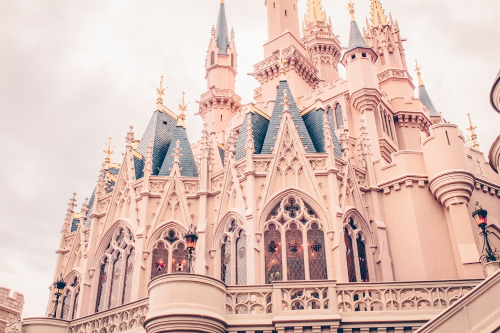 a large pink castle with a clock on it's side