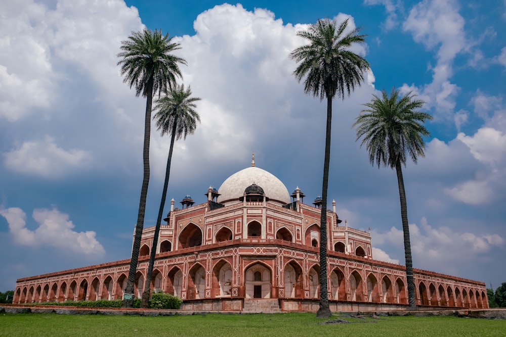 a building with a dome surrounded by palm trees