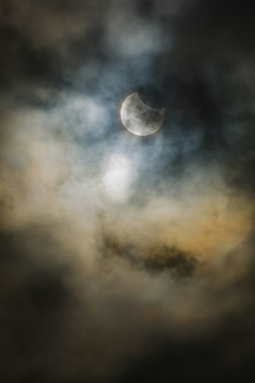 the moon is seen through the clouds in the sky