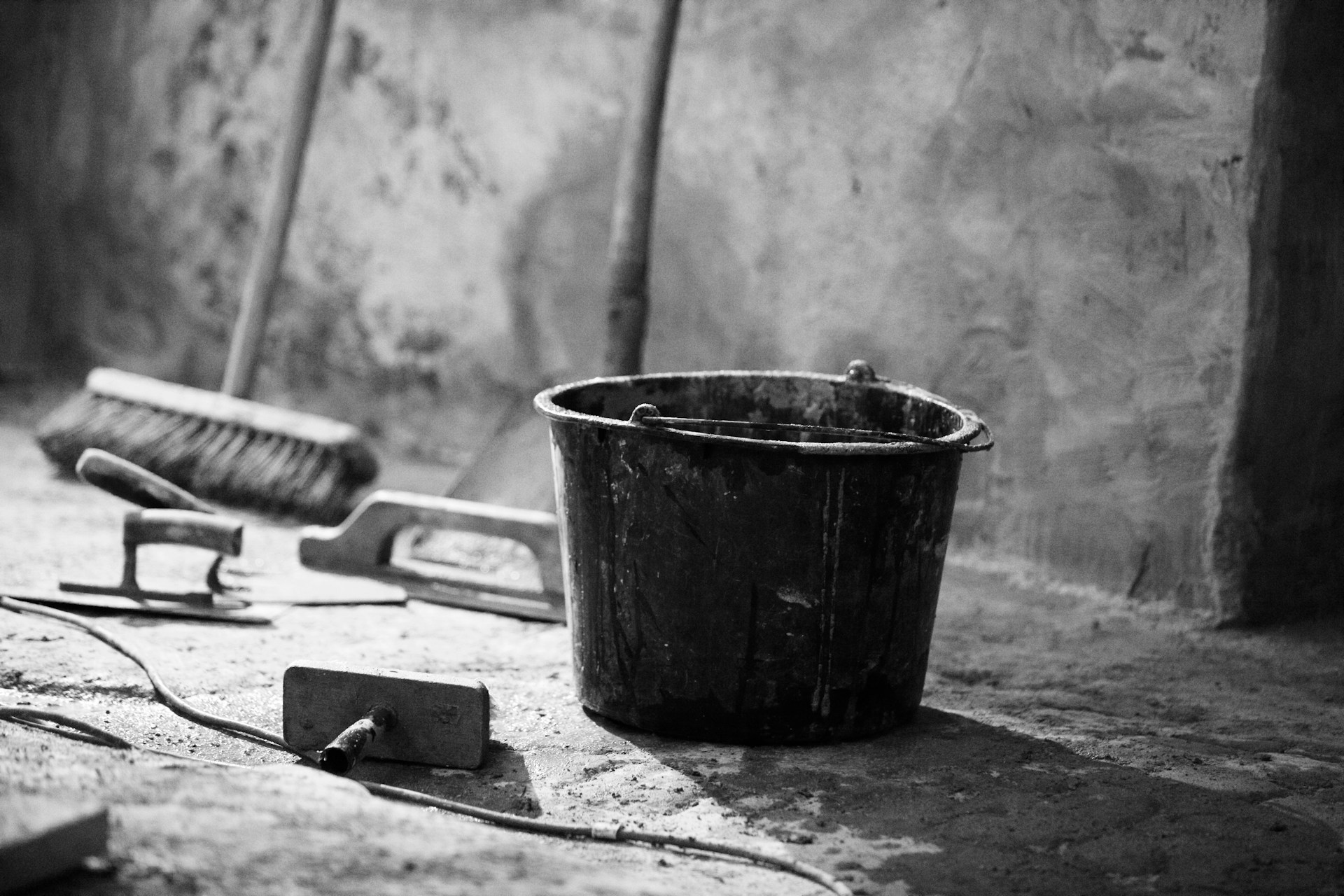 a bucket of paint and a brush on the ground