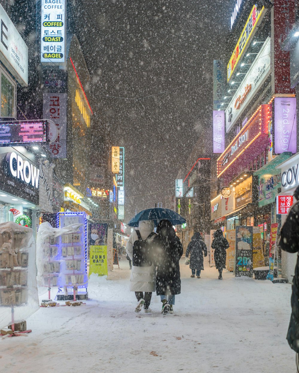 a group of people walking down a snow covered street