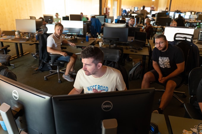 a group of men working on computers in an office