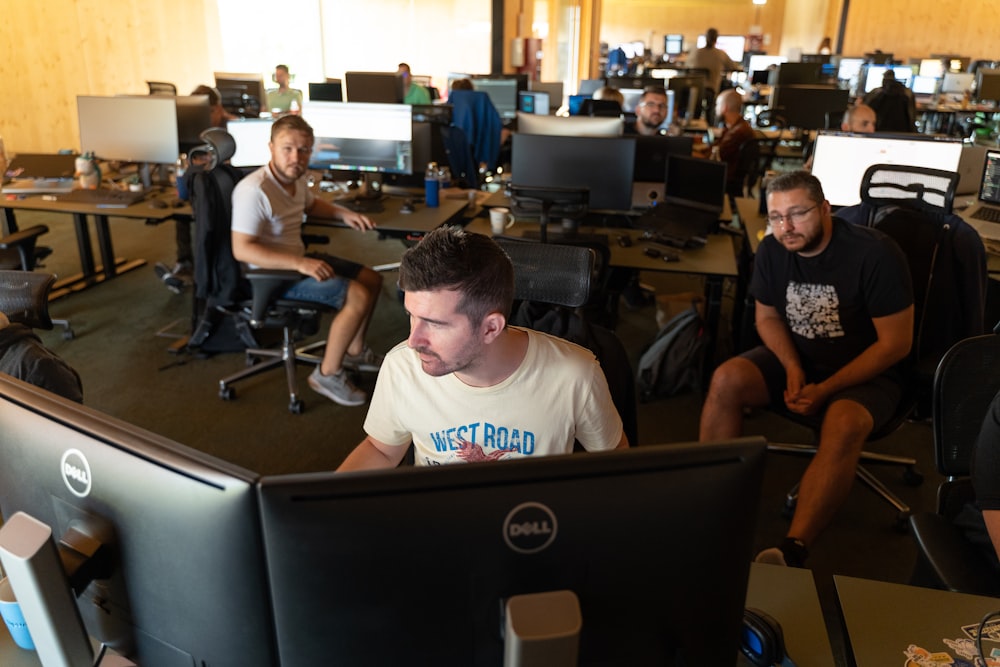 a group of men working on computers in an office