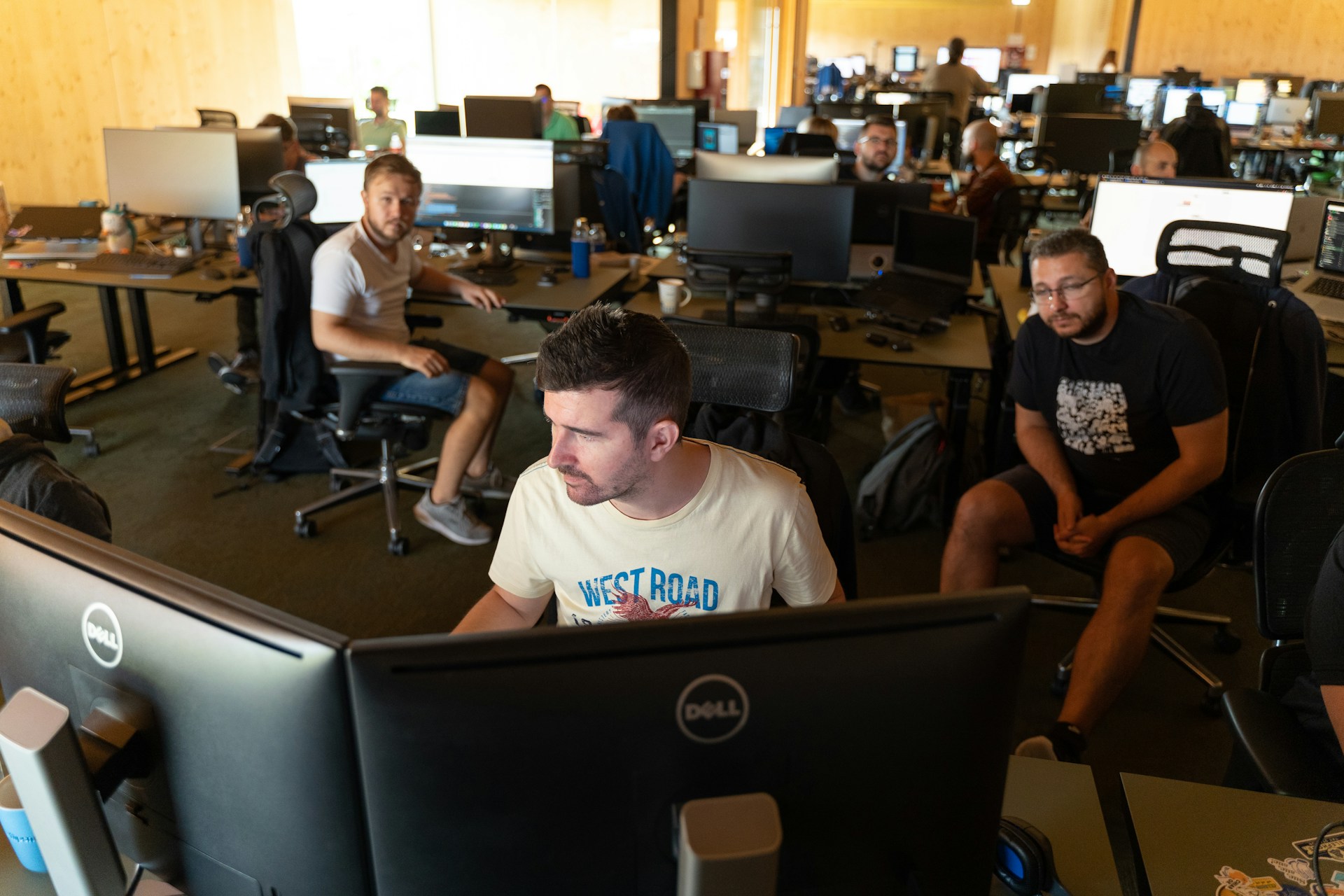 a group of men working on computers in an office