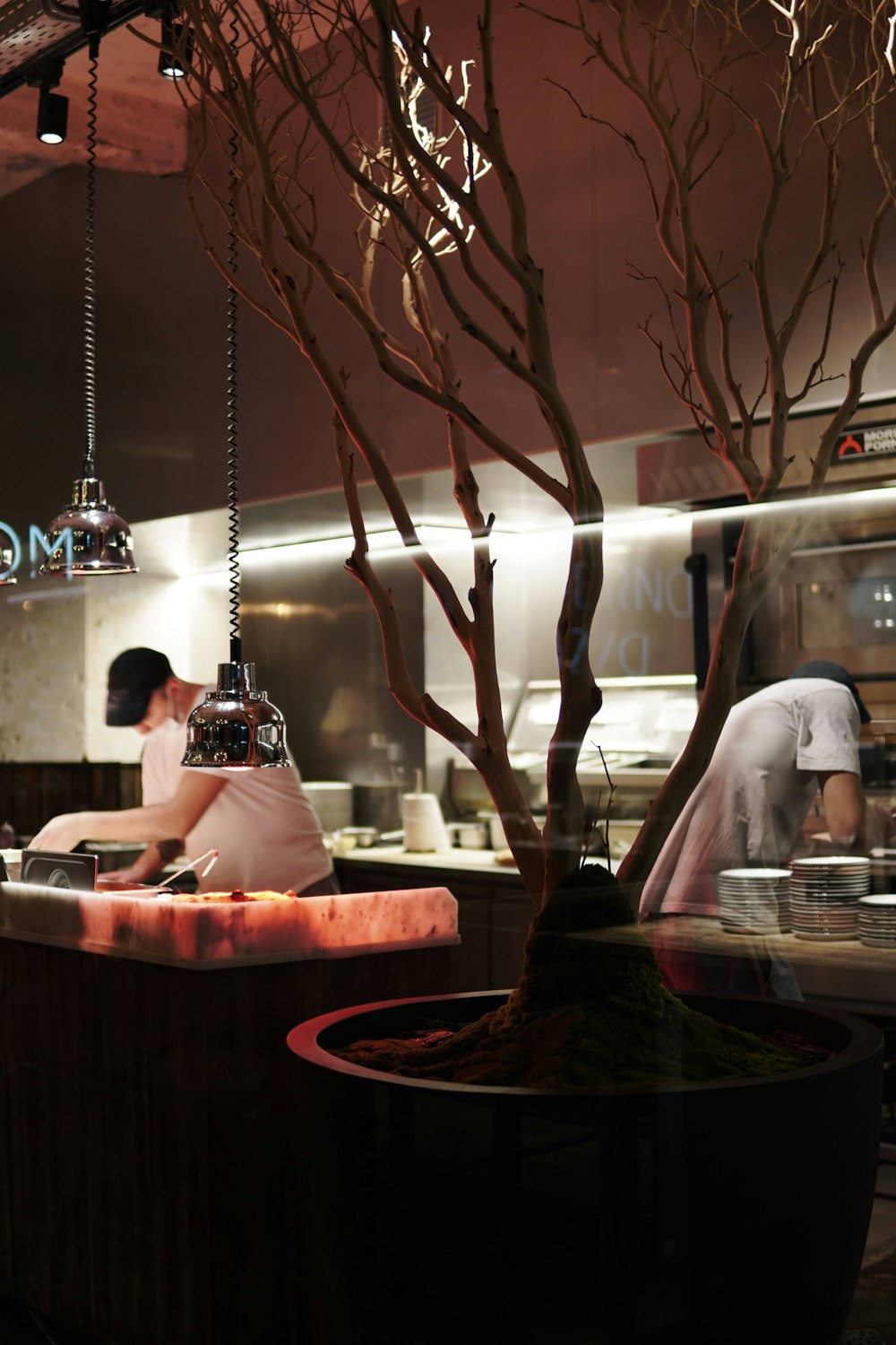 a couple of people in a kitchen preparing food