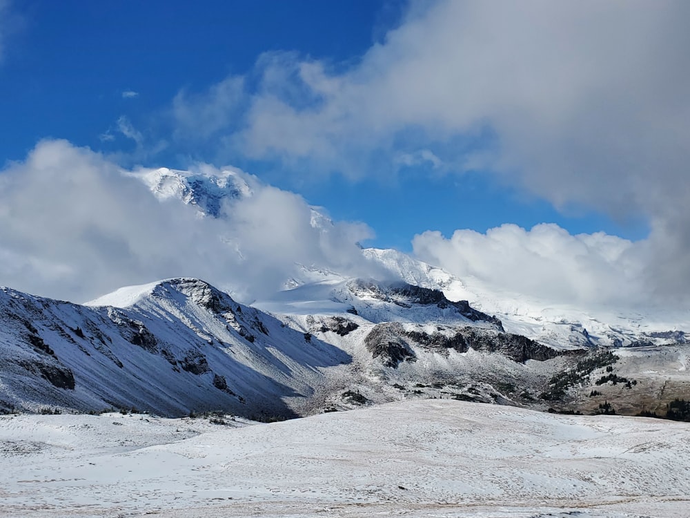 Une chaîne de montagnes enneigée sous un ciel bleu nuageux