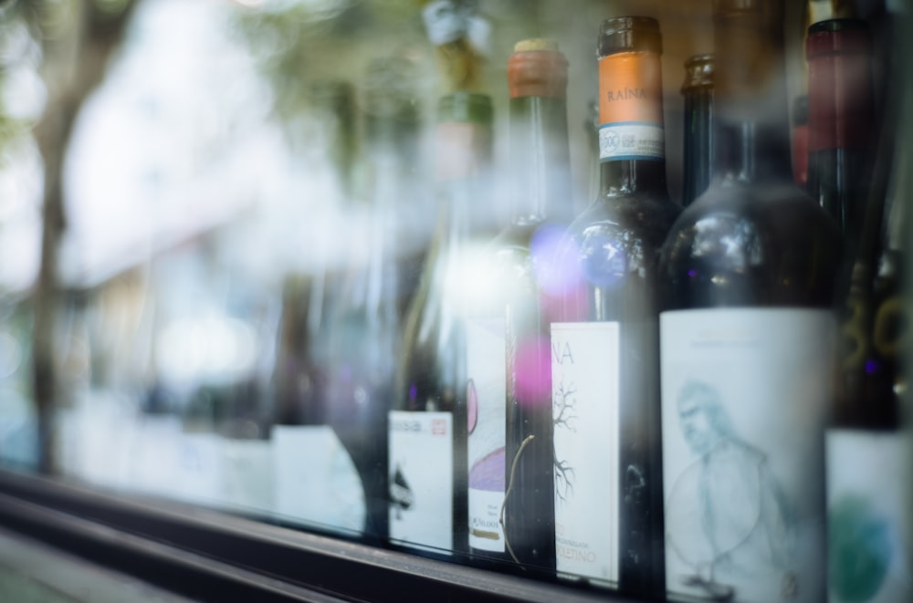 several bottles of wine sitting on a window sill