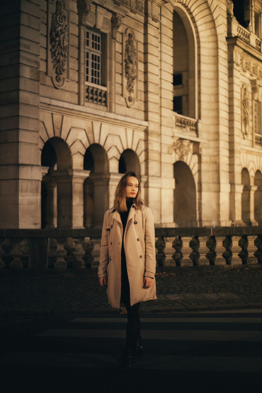 a woman standing in front of a building at night