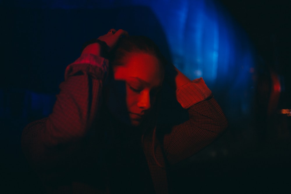 a man sitting in a dark room with his hands on his head