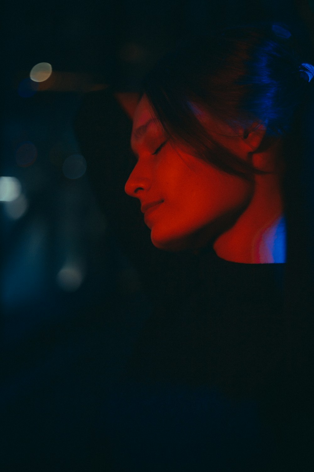 a woman with her eyes closed in the dark