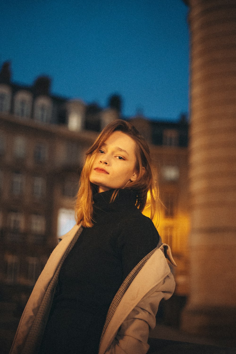 a woman standing in front of a tall building