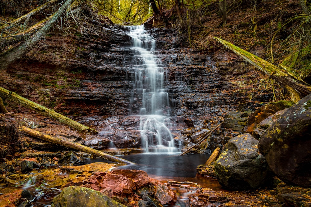 a small waterfall in the middle of a forest