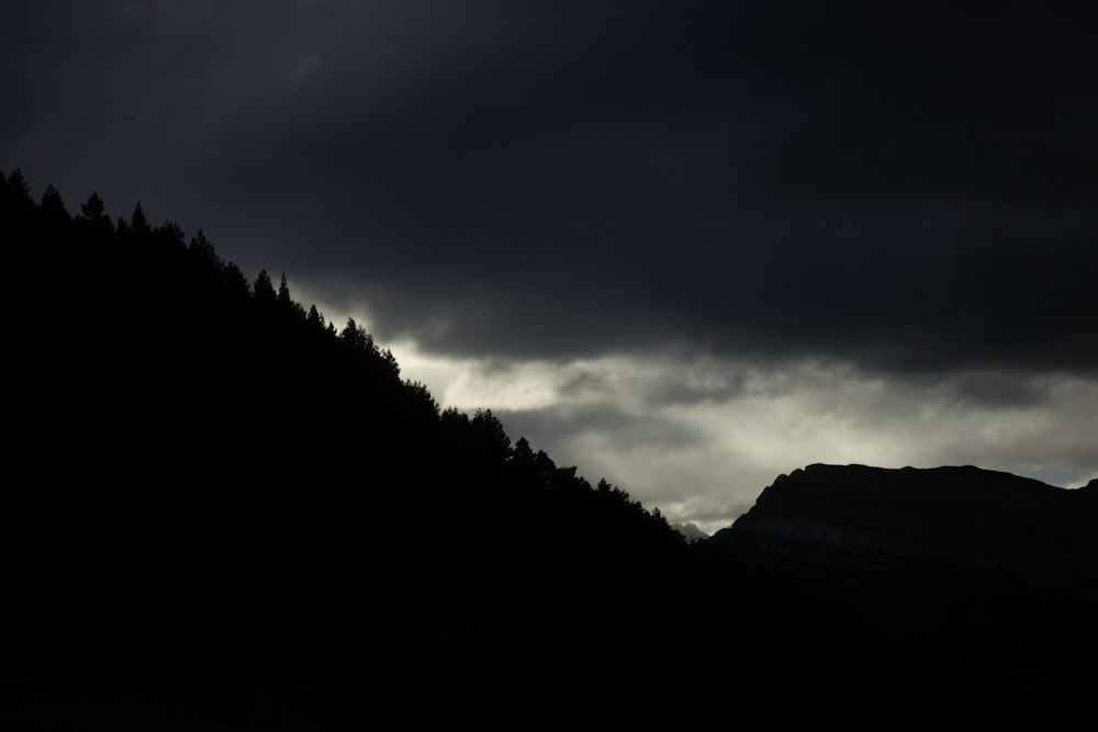 a dark mountain with a dark sky in the background