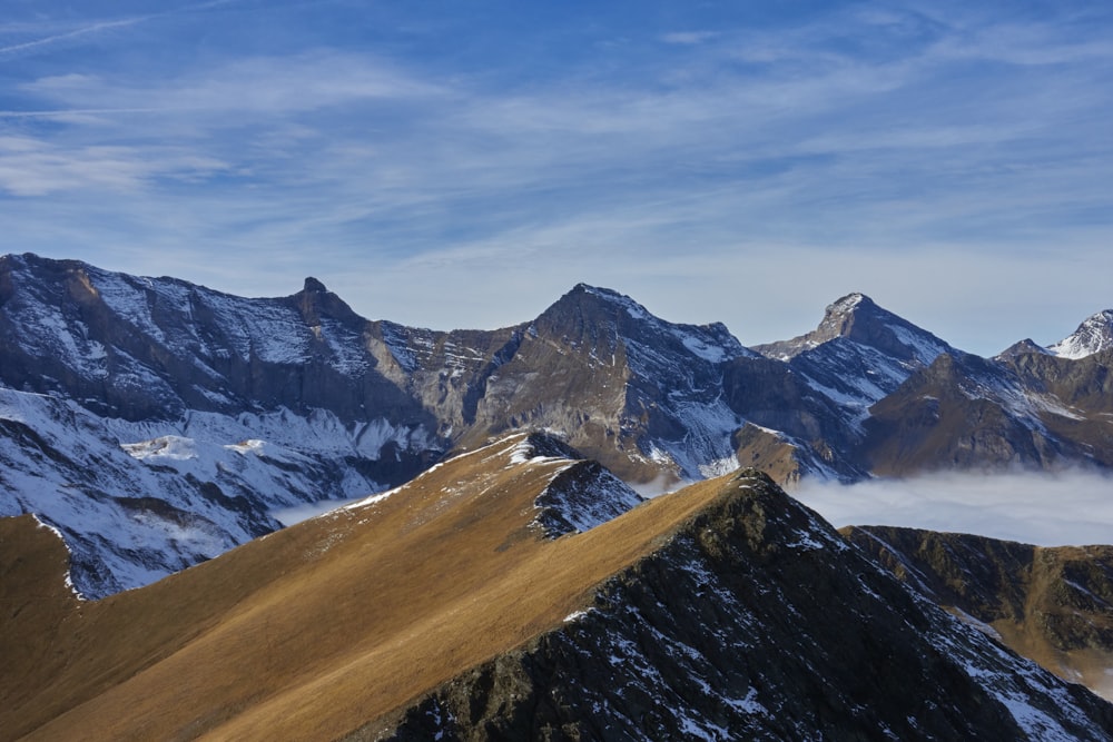 a group of mountains covered in snow under a blue sky