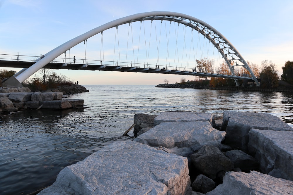 a bridge over a body of water with rocks in front of it