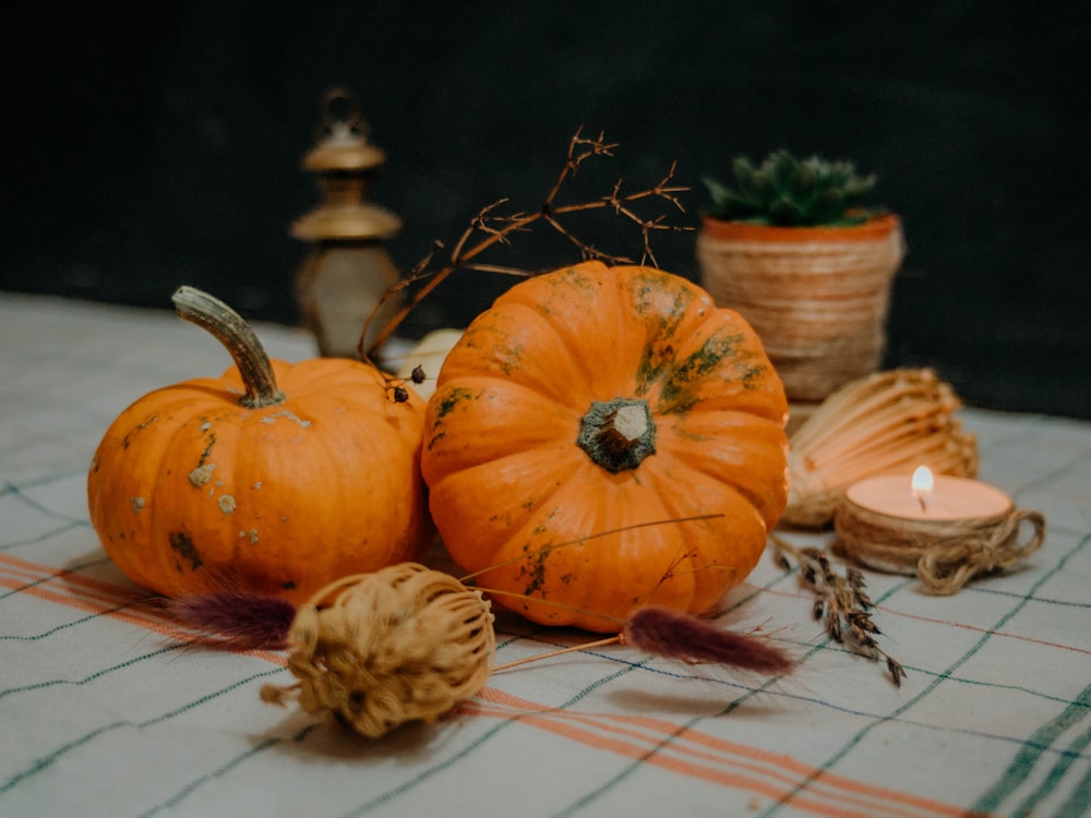 a table topped with lots of pumpkins and a candle