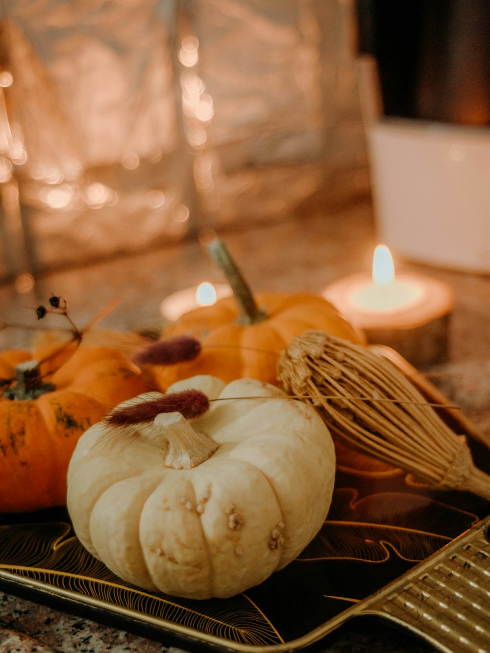 a table topped with pumpkins and a whisk