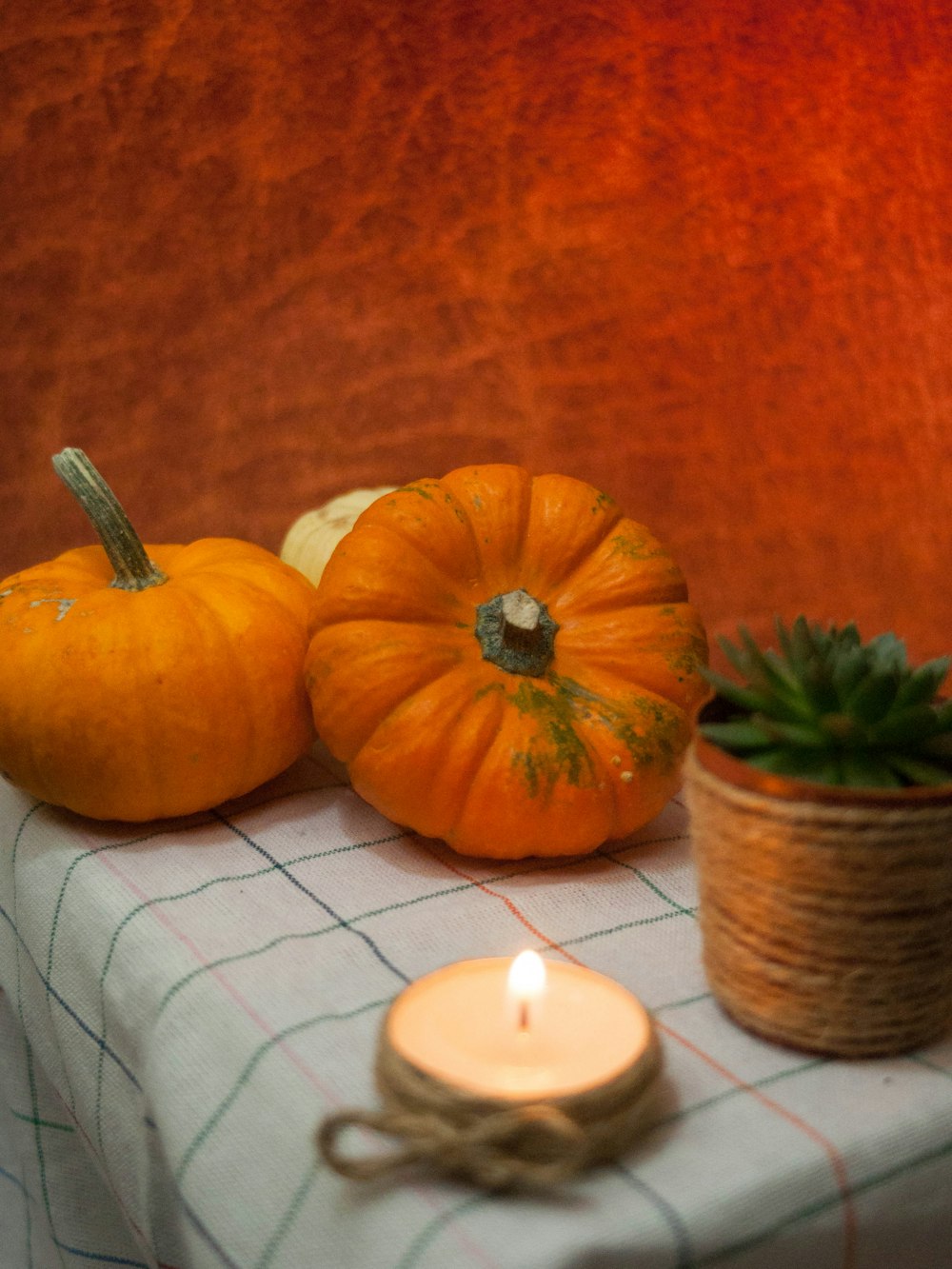 a table topped with two pumpkins and a candle