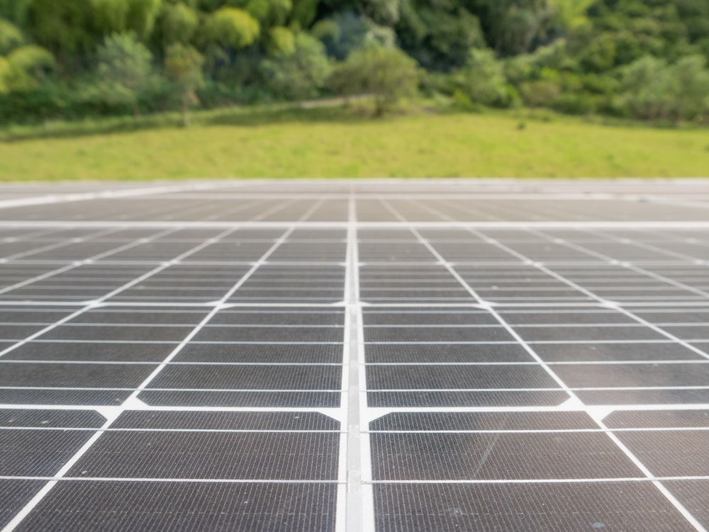 a close up of a solar panel with trees in the background