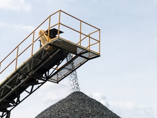 a large pile of gravel being loaded onto a truck
