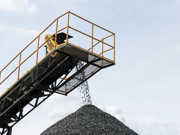 a large pile of gravel being loaded onto a truck