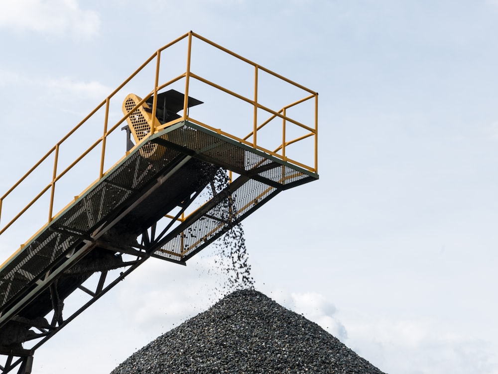 a large pile of gravel being loaded onto a truck