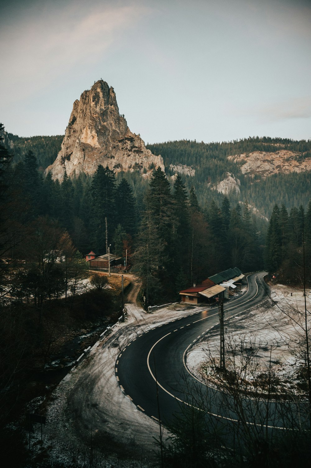 a winding road with a mountain in the background