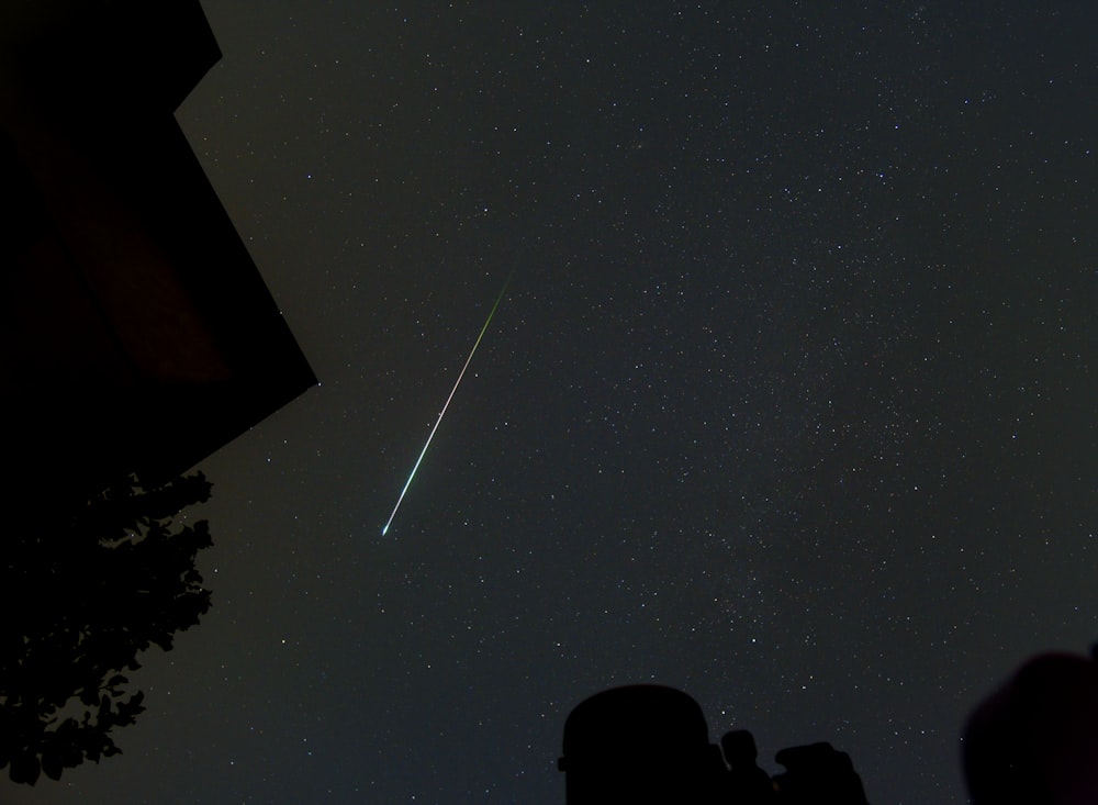 a shooting star is seen in the night sky