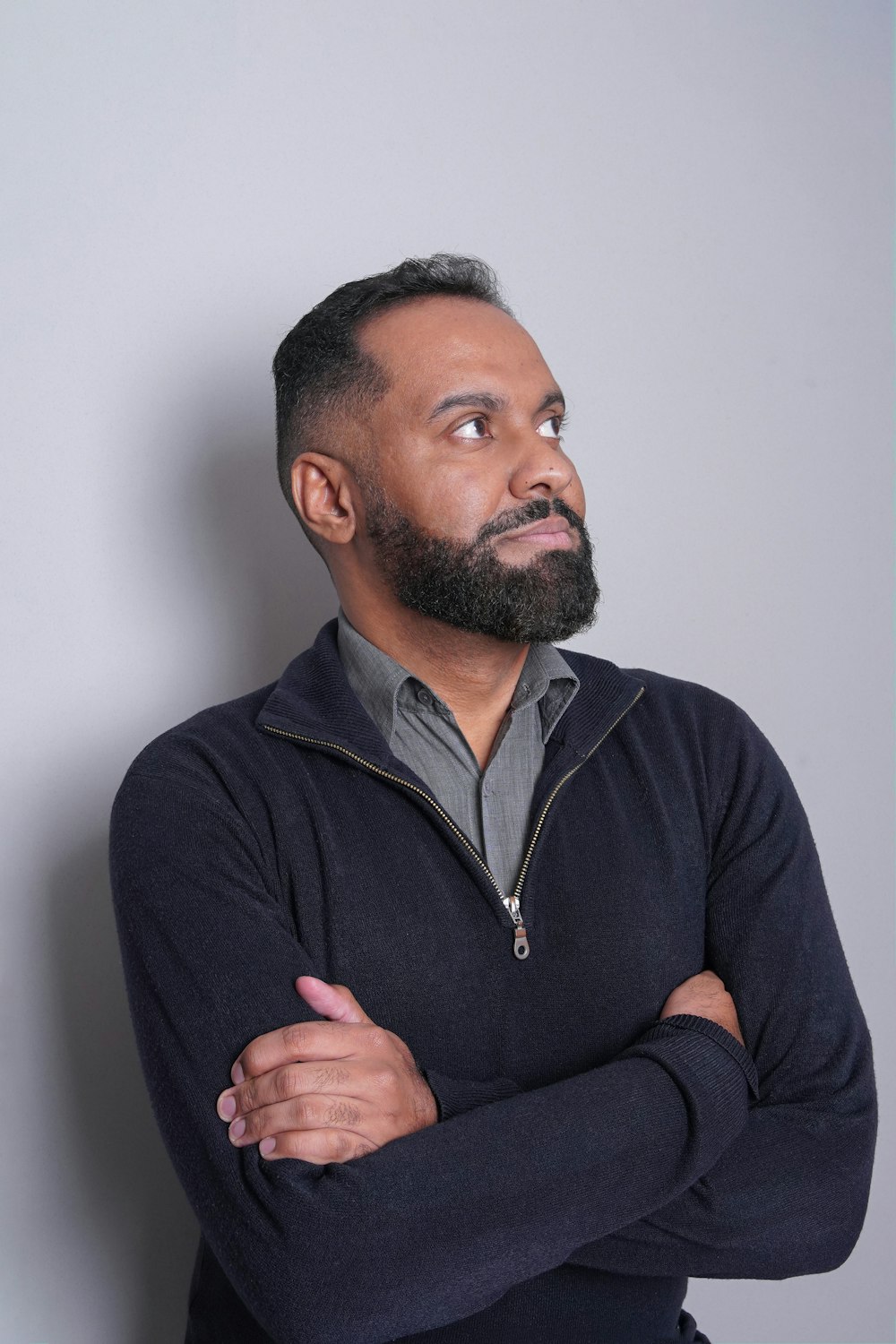 a man with his arms crossed looking up