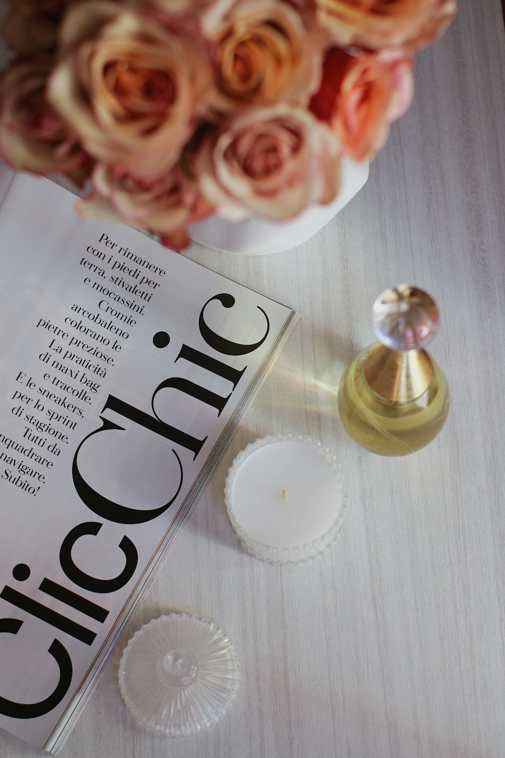 a table topped with a vase of flowers and a book