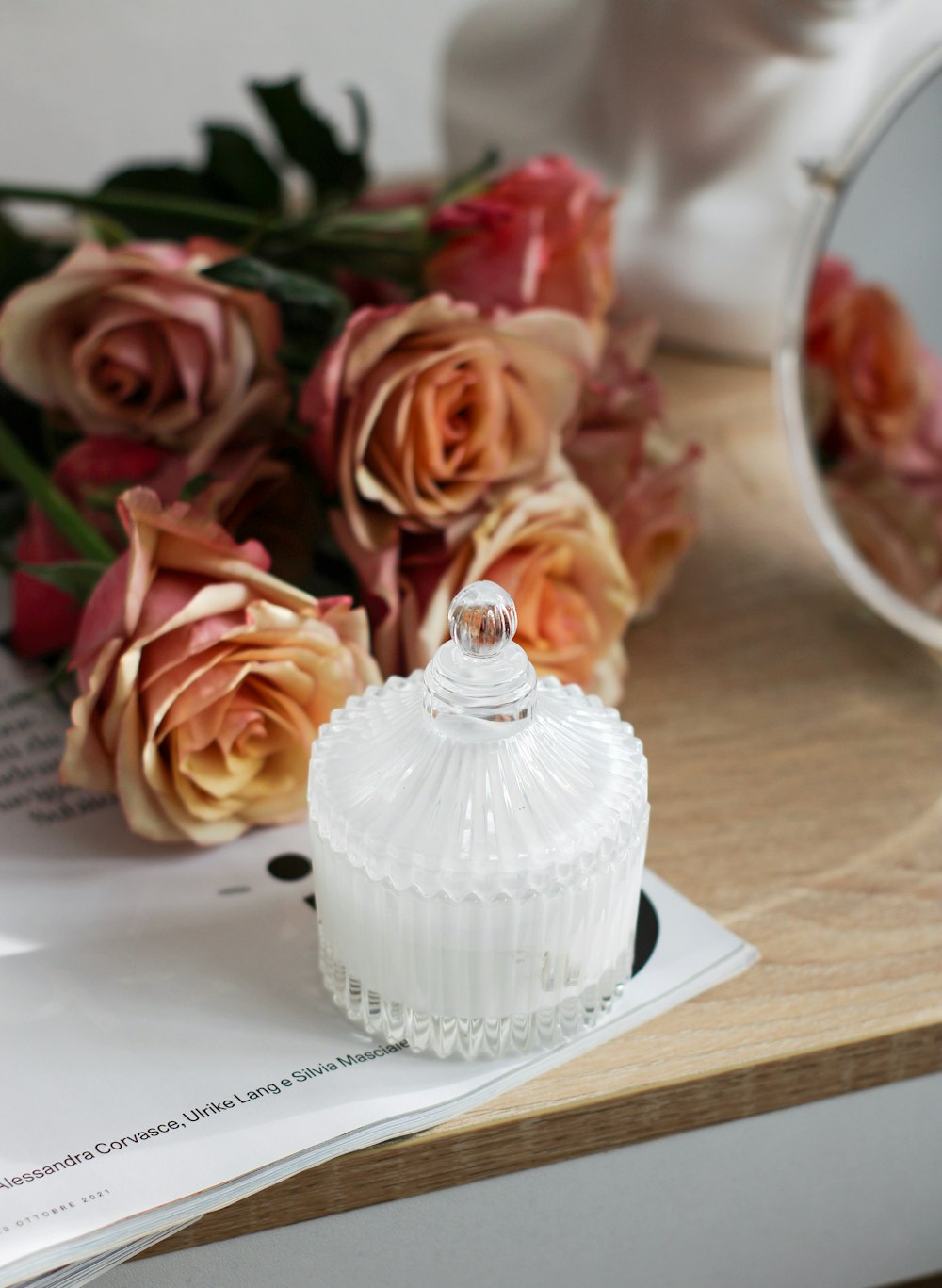 a white glass jar sitting on top of a wooden table