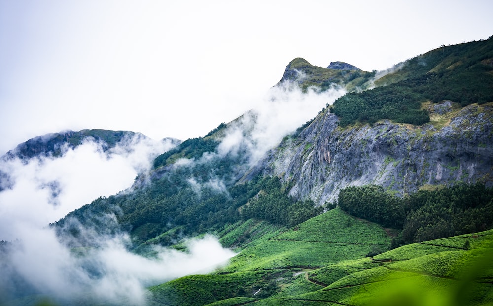 a view of a mountain with clouds and trees