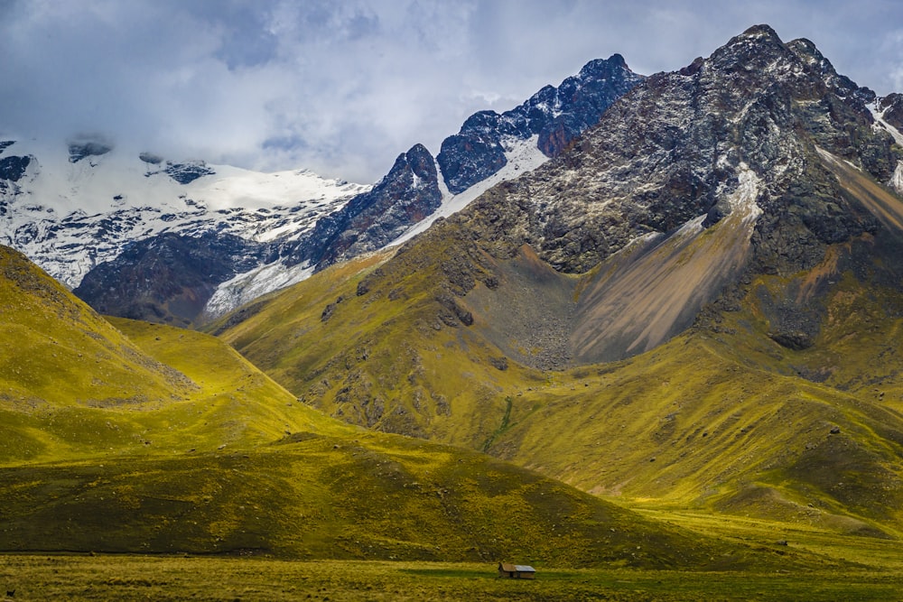 a mountain range with a house in the foreground