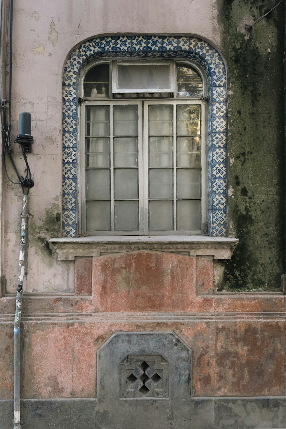 an old building with a window and a hose attached to it