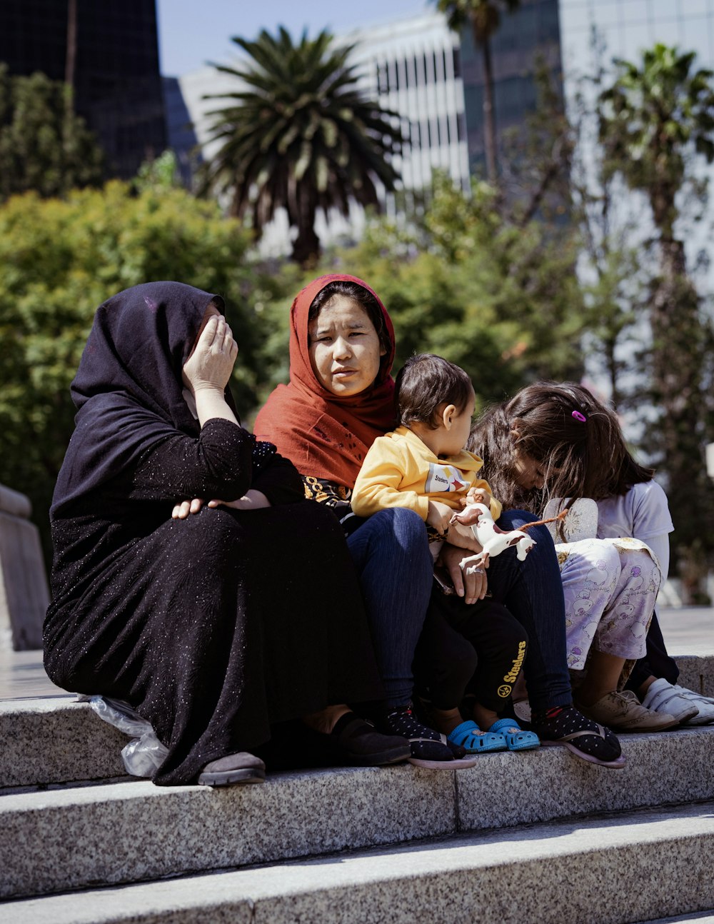 a woman sitting on steps with two children