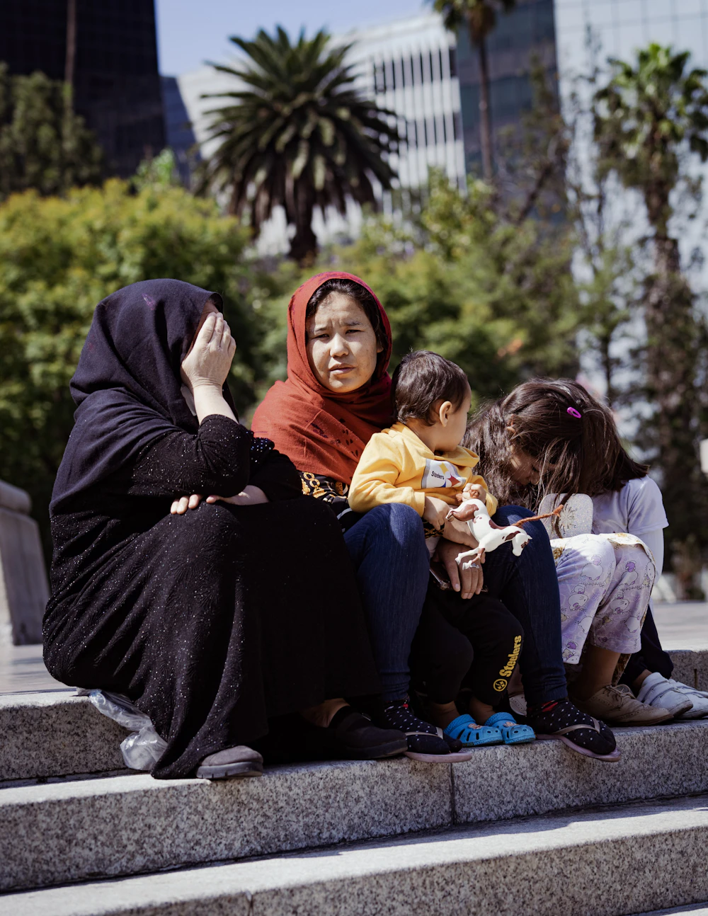 A mother sitting on steps with her two children